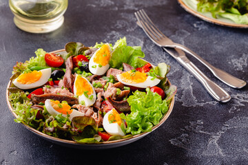 salad Nicoise with tuna, eggs, green beans, tomatoes,  olives, lettuce and anchovies