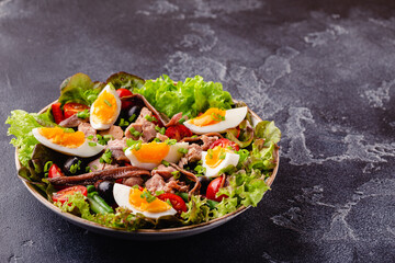 salad Nicoise with tuna, eggs, green beans, tomatoes,  olives, lettuce and anchovies