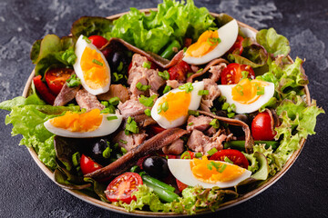 salad Nicoise with tuna, eggs, green beans, tomatoes,  olives, lettuce and anchovies