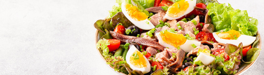 Fototapeta na wymiar salad Nicoise with tuna, eggs, green beans, tomatoes, olives, lettuce and anchovies