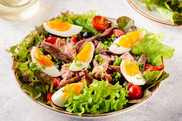 salad Nicoise with tuna, eggs, green beans, tomatoes,  olives, lettuce and anchovies