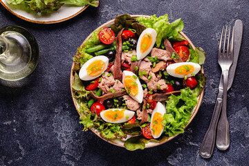 salad Nicoise with tuna, eggs, green beans, tomatoes,  olives, lettuce and anchovies