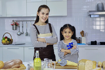 Mother and daughter prepare to happily bake in the kitchen during the holidays. Concept of love,...