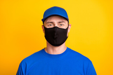 Portrait of deliveryman look camera headwear medical cold safety black mask isolated on yellow color background