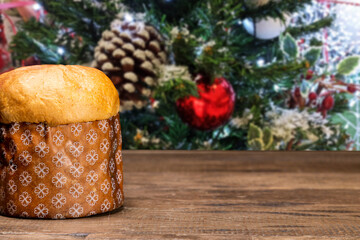 Panettone with christmas background, on wooden table.