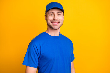 Portrait of half turned handsome working person smile headwear isolated on vibrant yellow color...