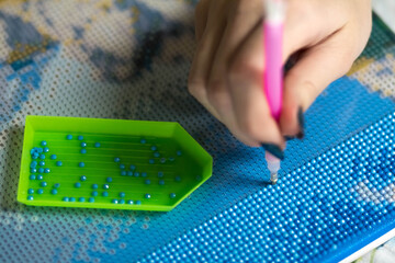 Collecting diamond embroidery, diamond mosaic. Colored crystals. Tools. Close up