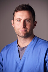 Obraz premium Studio Portrait Of Male Nurse Wearing Scrubs Standing Against Grey Background