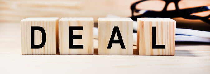 DAEL text on wooden cubes, glasses in the background.