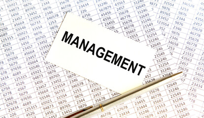 Obraz premium On the vcard is the MANAGEMENT text, next to reports and a pen.