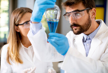 Researcher working with blue liquid at separatory funnel