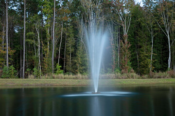fountain in park - water sprayed into the air creates a plume-like effect and long exposure gives it a silky look.