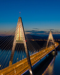 Fototapeta premium Budapest, Hungary - Aerial view of the beautiful illuminated Megyeri Bridge over River Danube at blue hour. 