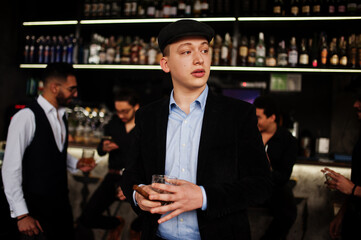 Stylish arab man against group of handsome retro well-dressed guys gangsters spend time at club, drinking on bar counter. Multiethnic male bachelor mafia party in restaurant.