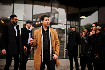 Fototapeta premium Group of handsome retro well-dressed man gangsters smoking outdoor. Multiethnic male bachelor mafia party.