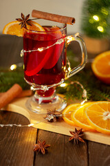 Christmas mulled wine red wine with spices and fruits on a wooden rustic table. Traditional hot drink for Christmas.