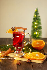 Christmas mulled wine red wine with spices and fruits on a wooden rustic table. Traditional hot drink for Christmas.