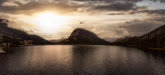 Beautiful Panoramic View of American Rockies Mountains. Dramatic Colorful Sunset Art Render. Taken in Swiftcurrent Lake, Glacier National Park, Montana, United States.
