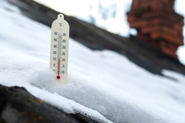 thermometer in the snow on the roof, the concept of global warming