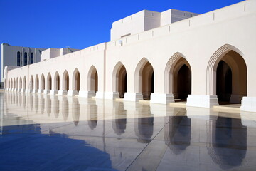 Mirrored view, on the polished floor, of the outer wall of the arcade, with contrasting blue sky in the background, Muscat, Oman