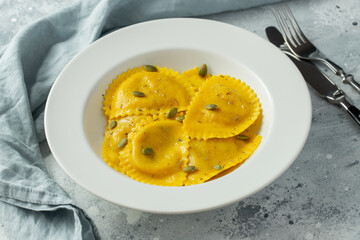 Homemade Pumpkin Ravioli with butter on a light concrete background. Top view