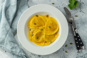Homemade Pumpkin Ravioli with butter on a light concrete background. Top view