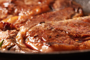 Marbled beef is cooked in a pan.