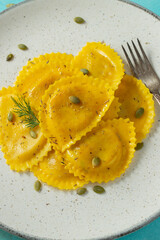Homemade Pumpkin Ravioli with butter on a light concrete background. Top view