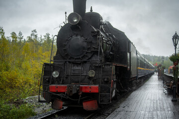 Fototapeta na wymiar Old retro vintage steam train on platform station Ruskeala Park