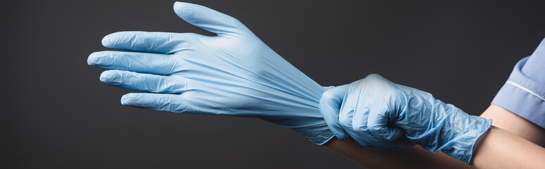 cropped view of nurse wearing latex gloves isolated on dark grey, 