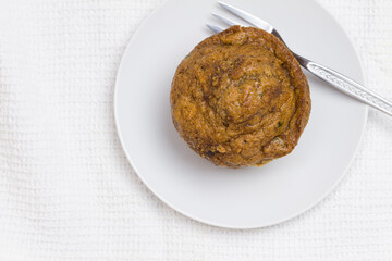 Muffin with cake fork, top view photo and copy space on white