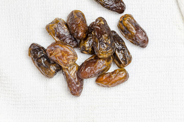 Dried dates on white cloth - top view image with copy space