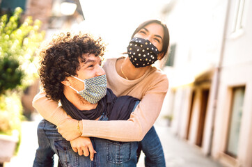 Happy couple of lovers enjoying winter travel time outdoor - Handsome guy with nice girl on piggy...
