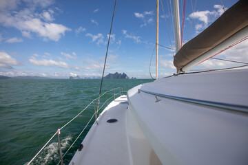 View of the blue sea water from the side of a sailboat with rigging and sails. Tackle barge, sail, masts, yards, deck, ropes