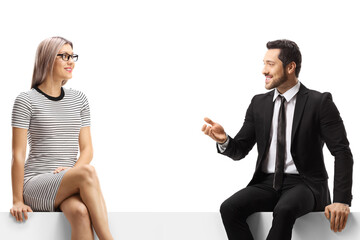 Young blond woman and a businessman sitting on a panel and talking
