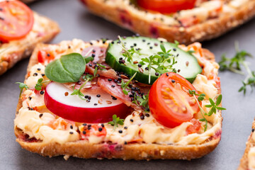 Sandwiches with cream cheese, vegetables and salami.
