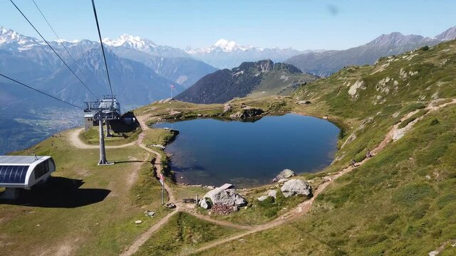 Cable car to Great Aletsch Glacier, largest in the Alps and UNESCO heritage from Moosfluh viewpoint in Valais Canton , Switzerland, Europe. Summer season, clear blue lake at cable car top. aerial view