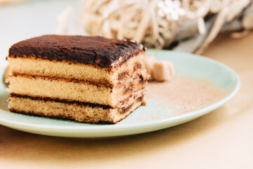 A piece of tiramisu tart in a green plate