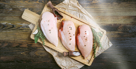 fresh raw farm chicken fillet on a cutting board.