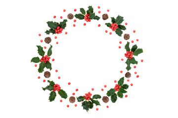 Natural Christmas, winter & New Year holly berry wreath with pine cones & loose red berries on white background. Flat lay top view, copy space. Design element.