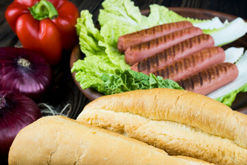 delicious grilled sausages and fresh vegetables with crunchy white bread lie in lettuce leaves on a clay plate, delicious food, juicy sausage, Bavarian sausages.