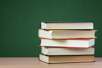 stack of textbooks on the table on a green.