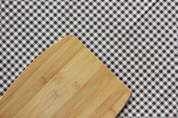 cutting Board on a checkered tablecloth, top view.