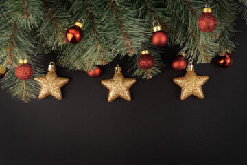Christmas tree and elements gold star, red ball , green pine tree branched on dark background with copy space for creative graphic design, print , postcard, new year party invitation card and so on.