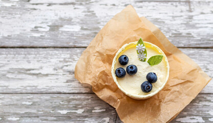 Top view on dessert made with white chocolate, meringue and blueberries on old wooden table.	
