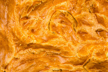 background, texture of the surface of a baked cake with a crispy crispy crust