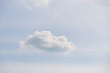 One fluffy cloud on a light blue sky background