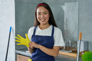 For a clean house. Portrait of joyful young woman, cleaning lady smiling at camera, wearing...