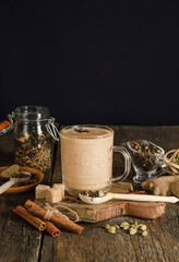 Masala tea with spices on black background with copy space, warming drink