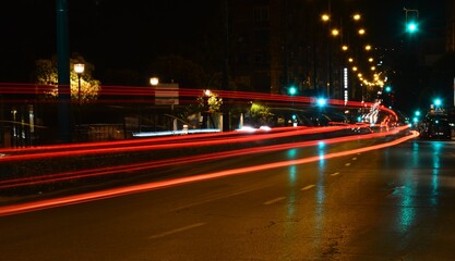 Calle iluminada  de una ciudad con todos los semáforos en verde